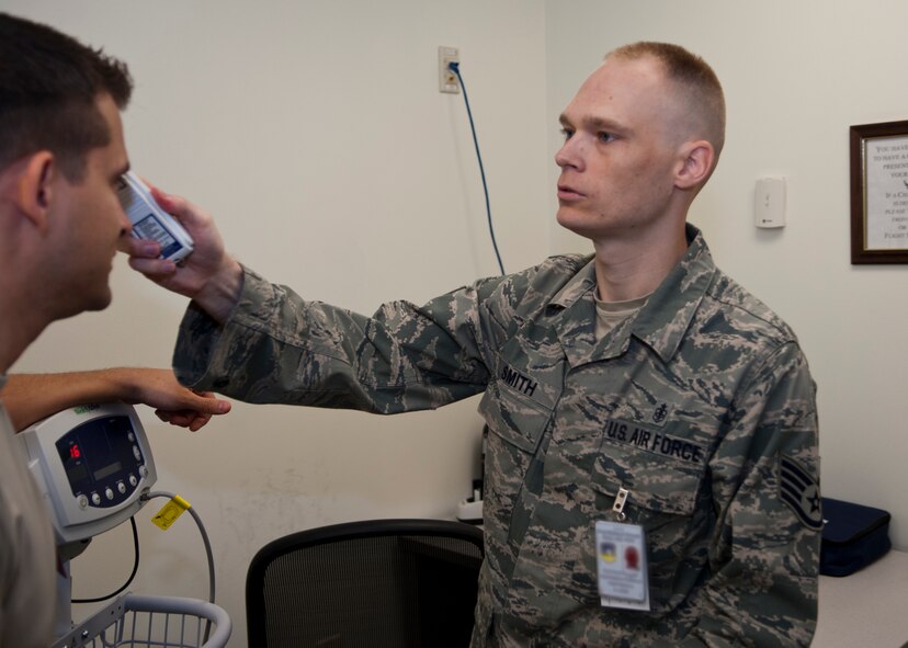 Staff Sgt. Benjamin Smith, 51st Aerospace Medicine Squadron flight medicine technician, takes a patient's temperature at Osan Air Base, Republic of Korea, June 7, 2013. Smith is this week’s Airman Spotlight winner. (U.S. Air Force photo illustration/Senior Airman Siuta B. Ika)