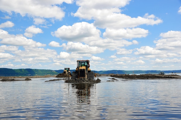 Bulldozers move dredge material to create islands in the Mississippi River as part of the Capoli Slough Habitat Rehabilitation and Enhancement Project. 