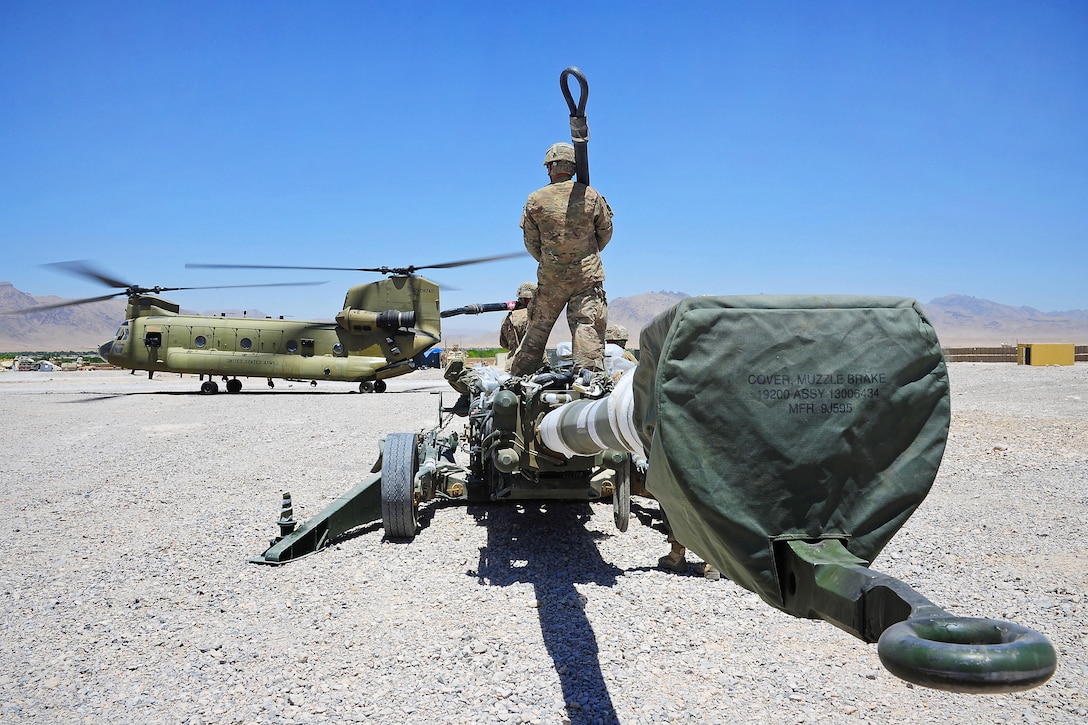 U.S. soldiers prepare to sling load a M777A2 howitzer to a CH-47 Chinook helicopter to be airlifted from Forward Operating Base Hadrian in Deh Rawud village in Uruzgan province to Kandahar Airfield in Afghanistan’s Kandahar province, June 18, 2013. The soldiers and helicopter crew are assigned to Task Force Knighthawk, 2nd Battalion, 10 Aviation Regiment.