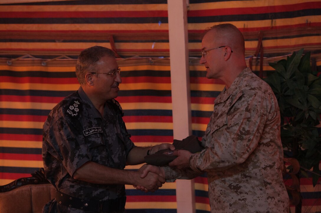 Brig. Gen. Gregg Olson, the commanding general of Marine Corps Forces Central Command (Forward), presents Jordanian Brig. Gen. Kassem Fadeel Nahar with gifts for his country's hospitality throughout Exercise Eager Lion 2013 at Camp Titin, Jordan, June 11, 2013. 