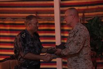 Brig. Gen. Gregg Olson, the commanding general of Marine Corps Forces Central Command (Forward), presents Jordanian Brig. Gen. Kassem Fadeel Nahar with gifts for his country's hospitality throughout Exercise Eager Lion 2013 at Camp Titin, Jordan, June 11, 2013. 