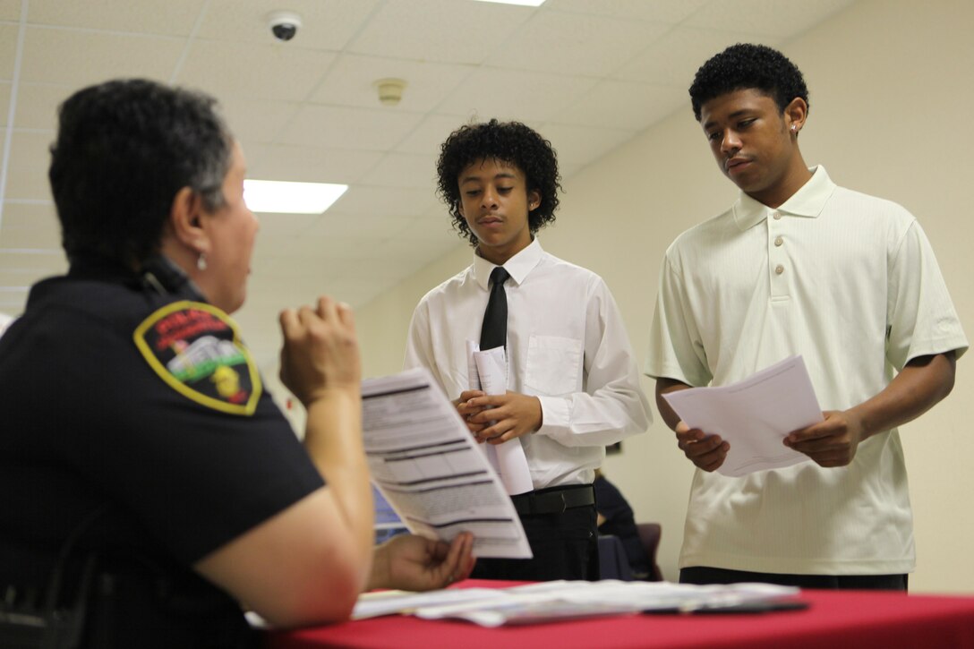 Devontae and Akiva Battle speak to Cpl. Daisy Haywood, a police officer with Jacksonville Police Department, about the Sturgeon City Institutes summer program held by the City of Jacksonville. The program offers week-long programs on photography, media, filmmaking, art, leadership, science and law enforcement.