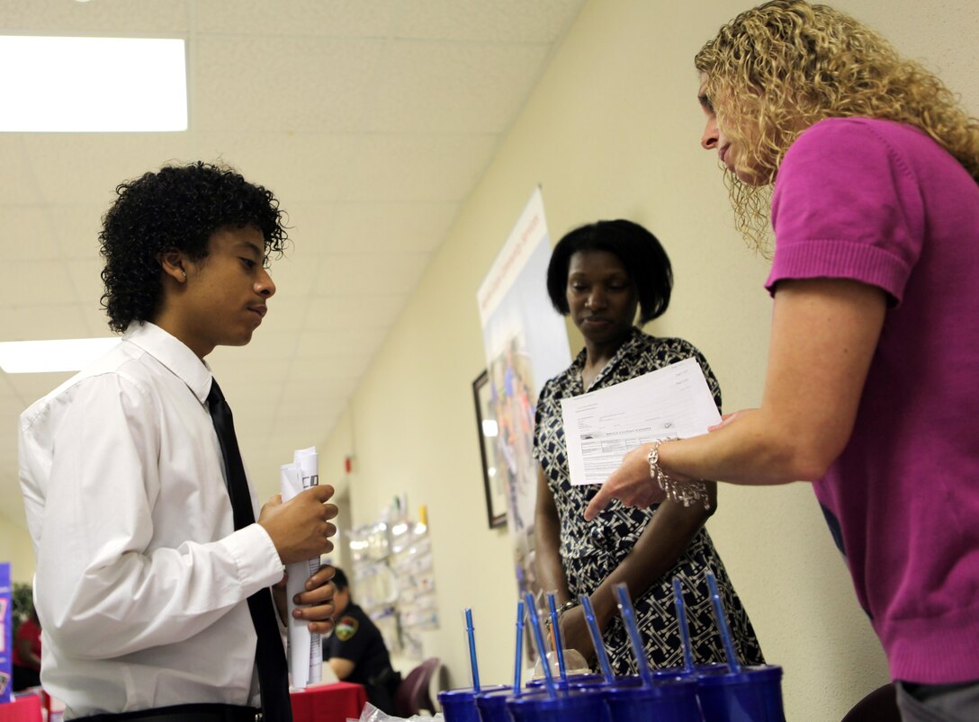Akiva Battle speaks to Amber Mirelis, a human resources technician with Marine Corps Community Services, about jobs available for teenagers during the Teen Job Fair held at the Russell Marine and Family Center May 18. MCCS is looking for lifeguards, camp counselors and other summer hires.