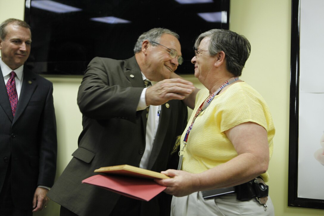 Captain Pam Sanders of the Onslow County Sheriff's Office is hugged by Sherriff Ed Brown after she was awarded with the Champion of Children award at a recent regnition ceremony hosted by the Child Advocacy Center of Onslow County. Naval Criminal Investigative Services, Onslow County Sheriff's Office, Jacksonville Police Department, Onslow County Department of Social Services, Onslow County District Attorneys Office and the Guns-and-Hoses Comittee were also honored at the ceremony. 