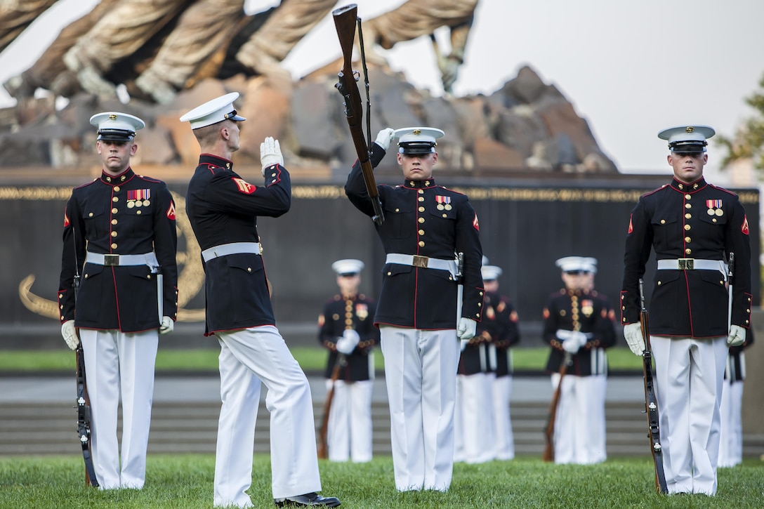 Cpl. Sean Breheny, a Marine Corps Silent Drill Platoon rifle inspector, prepares to catch an M1 Garand rifle during a Tuesday Sunset Parade at the Marine Corps War Memorial in Arlington, Va., June 25. 