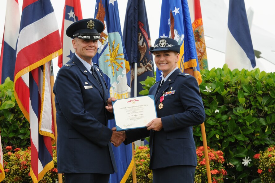 Col. Johnny Roscoe, 15th Wing commander, presents a Legion of Merit certificate to Col. Robie V. Hughes, former 15th Medical Group commander, prior to her change of command ceremony held at the Missing Man Formation on Joint Base Pearl Harbor-Hickam, Hawaii, June 24, 2013. The Legion of Merit is awarded for exceptionally meritorious conduct in the performance of outstanding services and achievements. The decoration is issued both to United States military personnel and to military and political figures of foreign governments. (Courtesy photo)