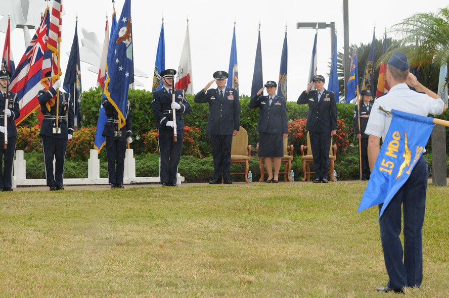Members of the 15th Wing Honor Guard present arms during the singing of the national anthem at the 15th Medical Group change of command ceremony at the Missing Man Formation on Joint Base Pearl Harbor-Hickam, Hawaii, June 24, 2013. During the ceremony, Col. Virginia A. Garner assumed command from Col. Robie V. Hughes. (Courtesy photo)