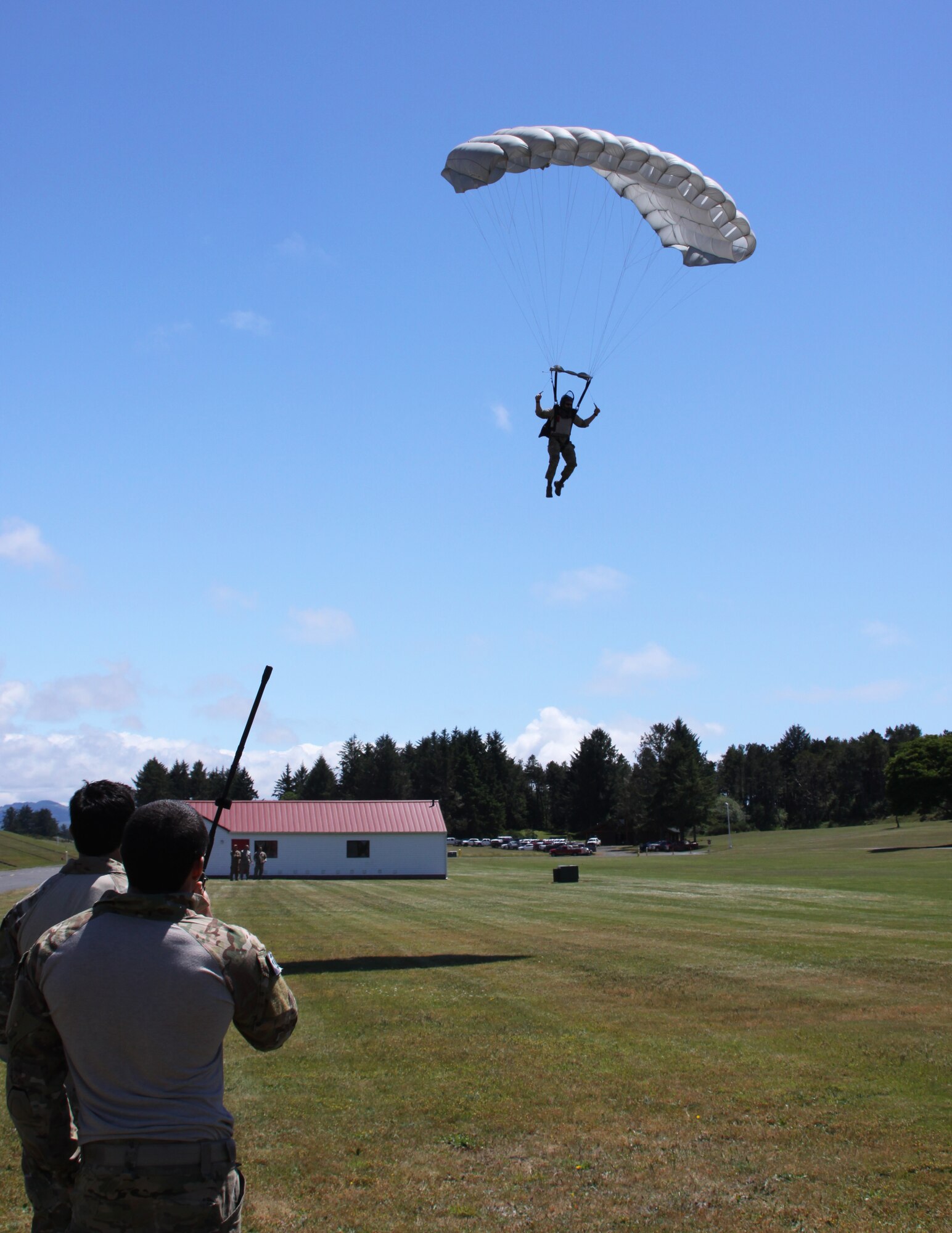 Members of the 125th Special Tactics Squadron, Portland Air National Guard Base, Portland, Ore., parachute into a parade field during a joint training operation at Camp Rilea Ore., June 21, 2013. The exercise was held over a three day period in which the Combat Operations Group (COG) made up of four individual Oregon Air Guard units; 125th STS, 116th Air Control Squadron, 270th Air Traffic Control Squadron, and the 123rd Weather Flight. The focus of the exercise was build unit morale, establish new professional networks and enhance military development. (Air National Guard Photo by Master Sgt. Shelly Davison, 142nd Fighter Wing Public Affairs).