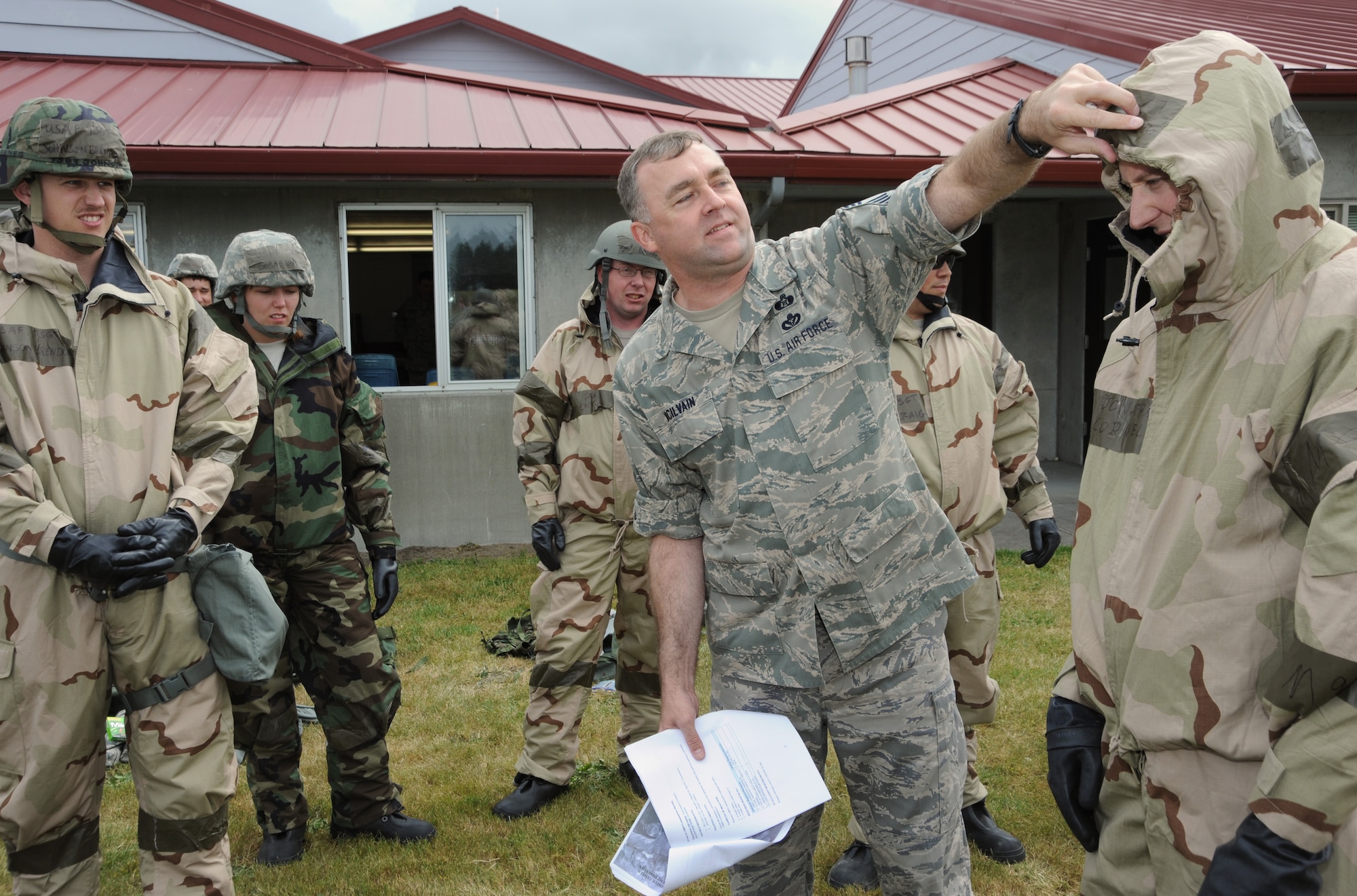 Oregon Air National Guard Chief Master Sgt. John McIlvaine of the 142nd Fighter Wing trains Airmen of the 270th Air Traffic Control Squadron on using their chemical gear during joint training with the Combat Operations Group at Camp Rilea, Ore., June 21, 2013. (Air National Guard photo by Tech. Sgt. John Hughel, 142nd Fighter Wing Public Affairs)