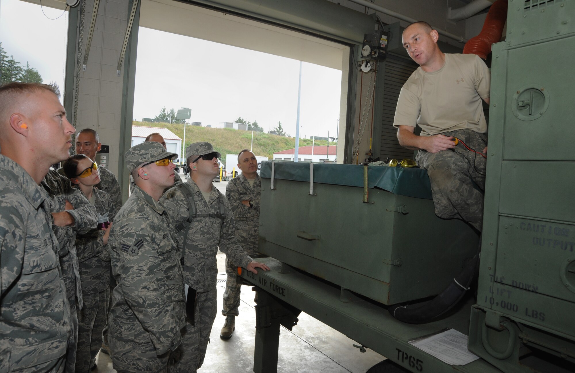 Oregon Air National Guard Tech. Sgt. Richard Lowe, 116th Air Control Squadron describes one of the generators the unit maintains to member of the 270th Air Traffic Squadron during a joint training session of the Combat Operations Group at Camp Rilea, Ore., June 21, 2013. (Air National Guard photo by Tech. Sgt. John Hughel, 142nd Fighter Wing Public Affairs)