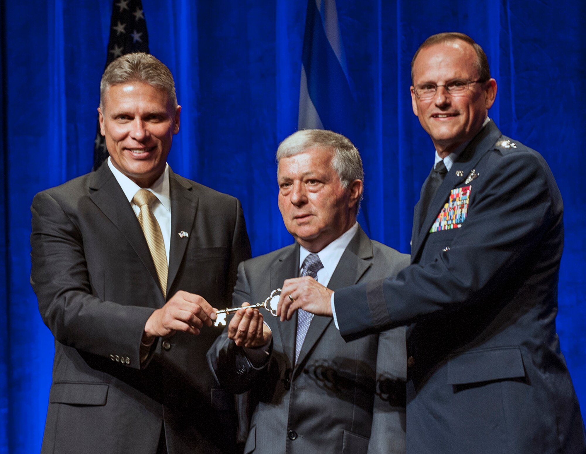 Maj. Gen. Richard Johnston, assistant deputy under Secretary of the Air Force, International Affairs, assists George Shultz, vice president and general manager, C-130 Programs, Lockheed martin Aeronautics Company, in passing the aircraft’s golden key to Aharon Marmarosh, director, Government of Israel Ministry of Defense, Mission to the United States of America, during a delivery ceremony of the first C-130J Super Hercules aircraft to the State of Israel at the Lockheed Martin Aeronautics production facility, Marietta, Ga., June 26. This is the first of three C-130Js currently on order for the Israeli Air Force. (Photo/Lockheed Martin)