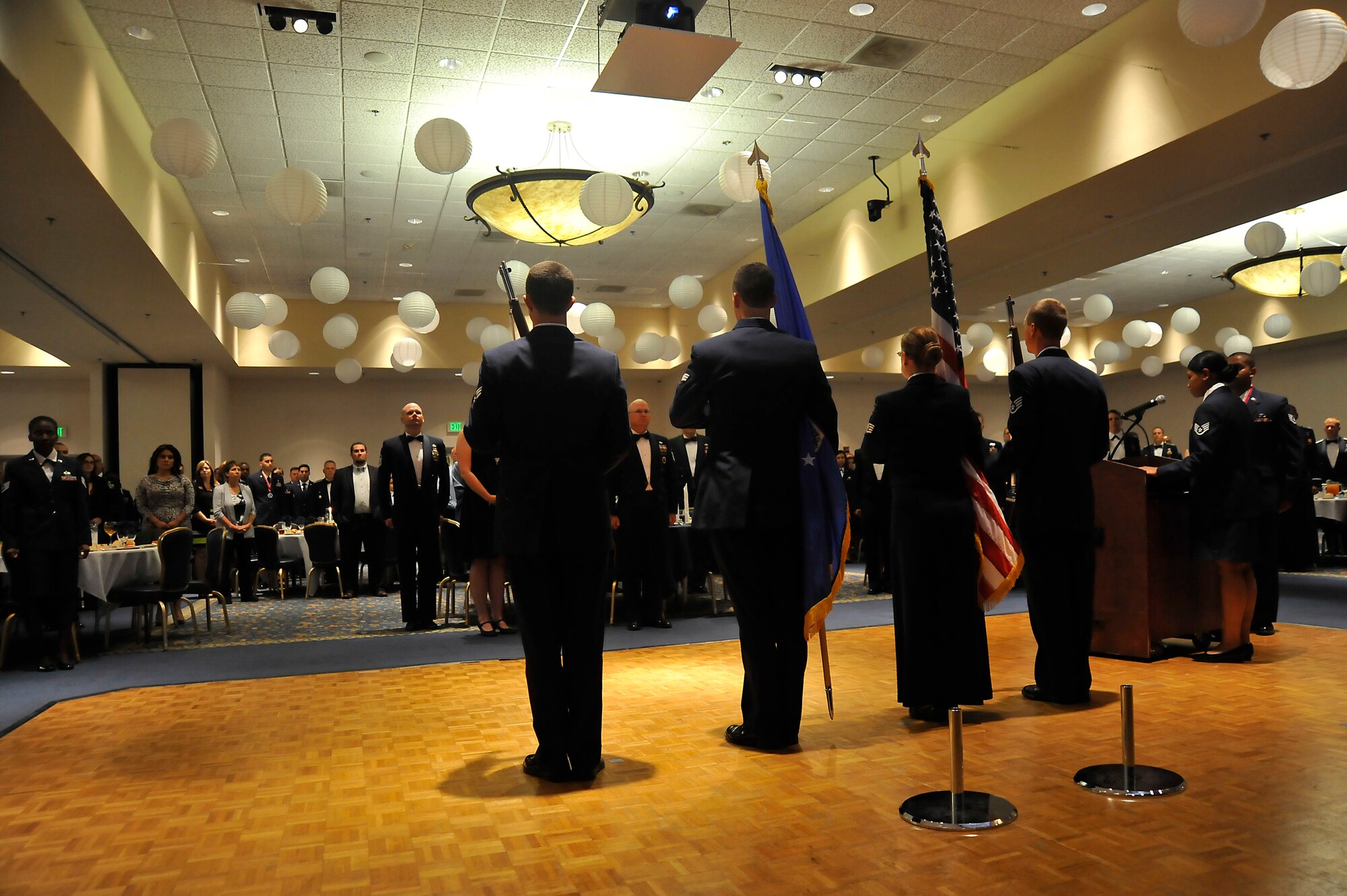 VANDENBERG AIR FORCE BASE, Calif. -- Guests stand as a color guard team prepares to post the colors during an Airman Leadership School graduation ceremony for class 13-E here Thursday, 20 June. ALS is a five week-long United States Air Force program designed to develop airmen into effective front-line supervisors, focusing on the development of leadership abilities as well as effective communication. (U.S. Air Force photo/Michael Peterson)