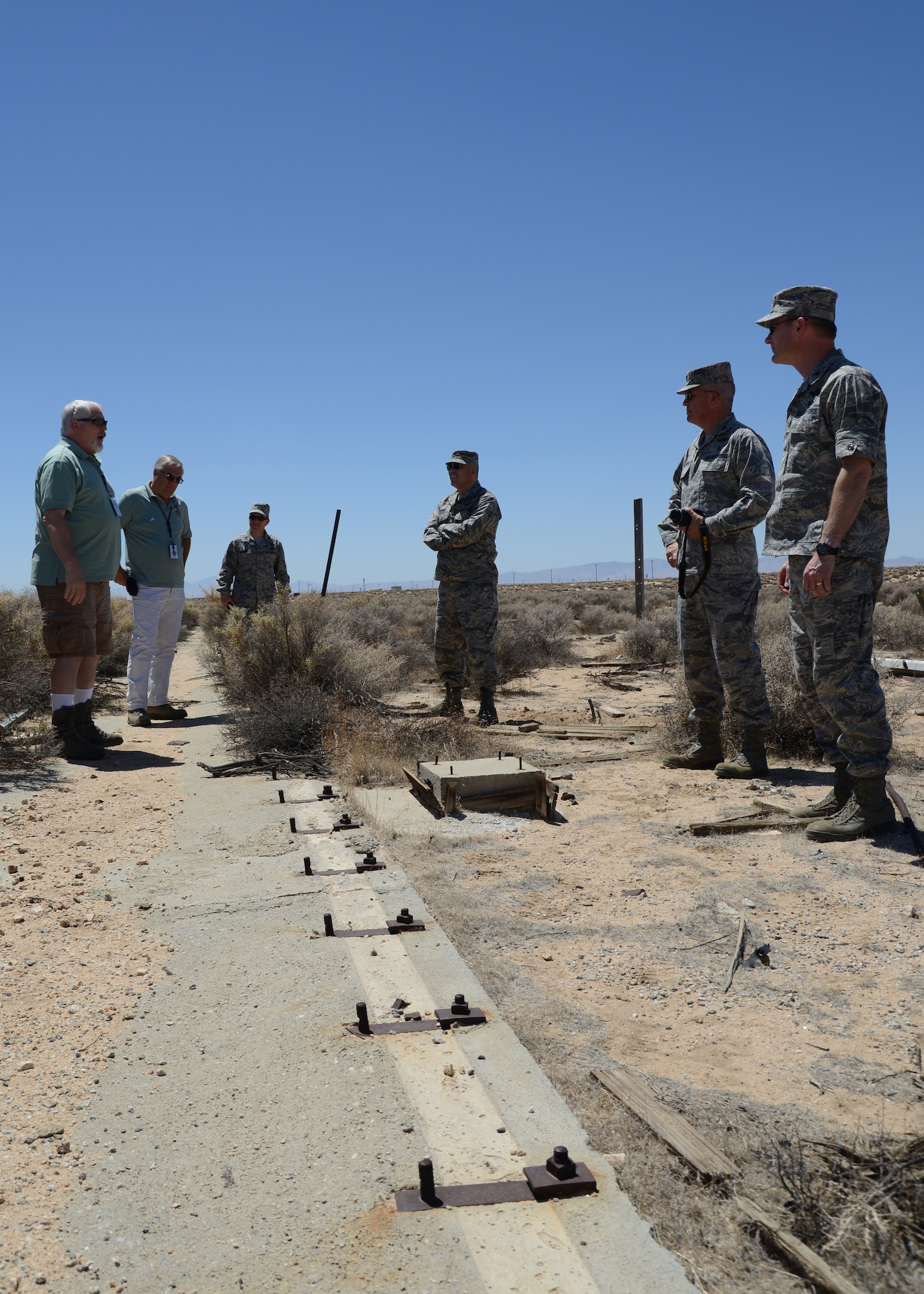 Air Force Flight Test Museum specialist Tony Moore talks with base leaders about the rocket sled track where Dr. John Stapp conduncted important research on deceleration. It was one of several stops on a recent tour of historical sites located throughout the base for base leadership. (U.S. Air Force Photo by Laura Mowry)