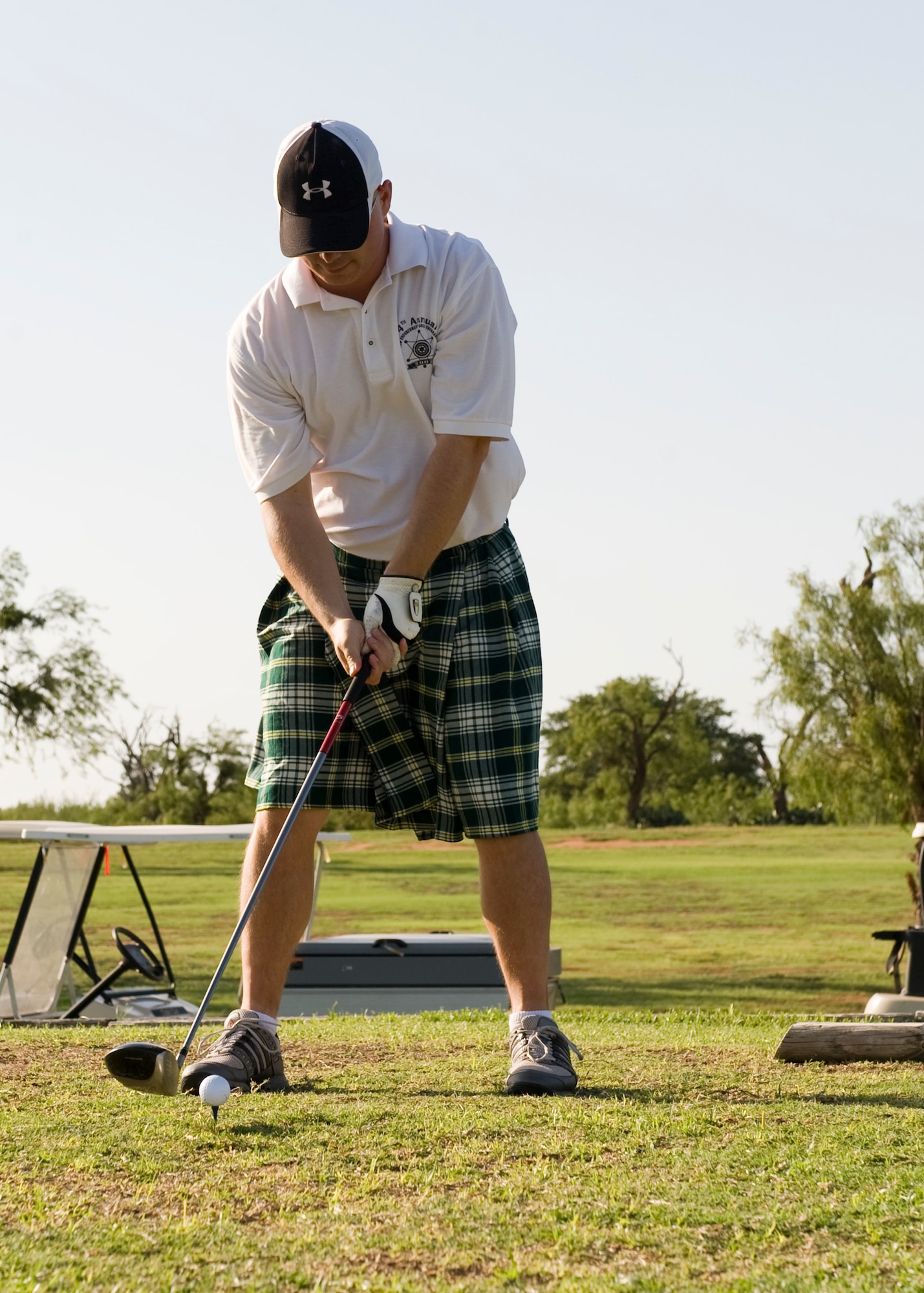 U.S. Air Force Maj. Patrick Bass, 7th Security Forces Squadron commander, prepares to tee off during a golf tournament June 21, 2013, at Dyess Air Force Base, Texas. Participants of the night golf tournament played the first nine holes during the daytime with the following nine at night. (U.S. Air Force photo by Airman 1st Class Peter Thompson/Released)