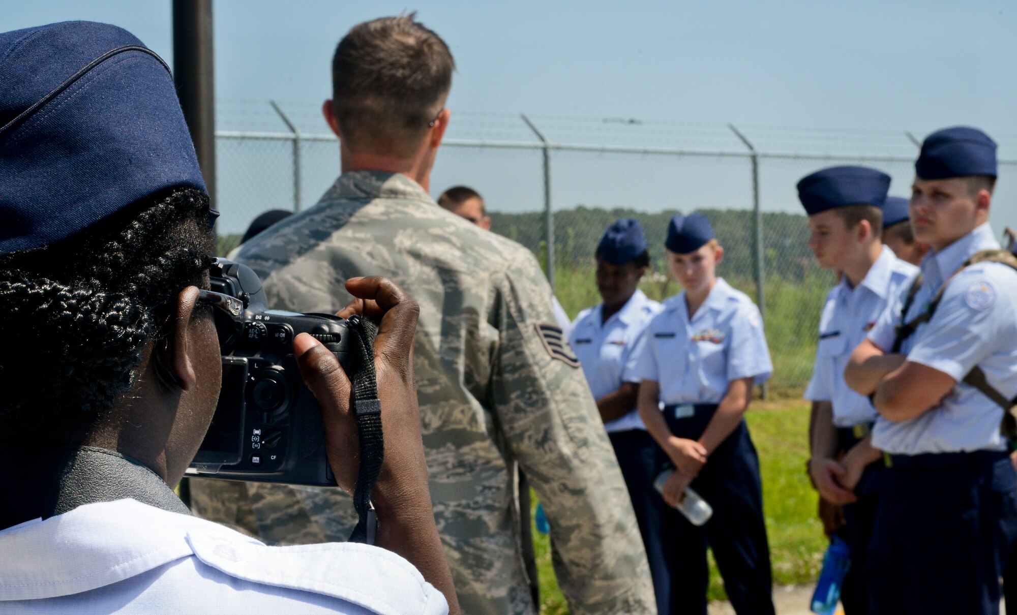 Sierra Johnson, a Hampton High School U.S. Air Force Junior Reserve Officers' Training Corps cadet, takes a photo of her fellow students while following a public affairs specialist during a shadow day event at Langley Air Force Base, Va., June 25, 2013. Johnson was one of approximately 80 cadets from four high schools paired with more than 50 Airmen to learn about the Air Force mission during their weeklong summer leadership program. (U.S. Air Force photo by Airman 1st Class R. Alex Durbin/Released)