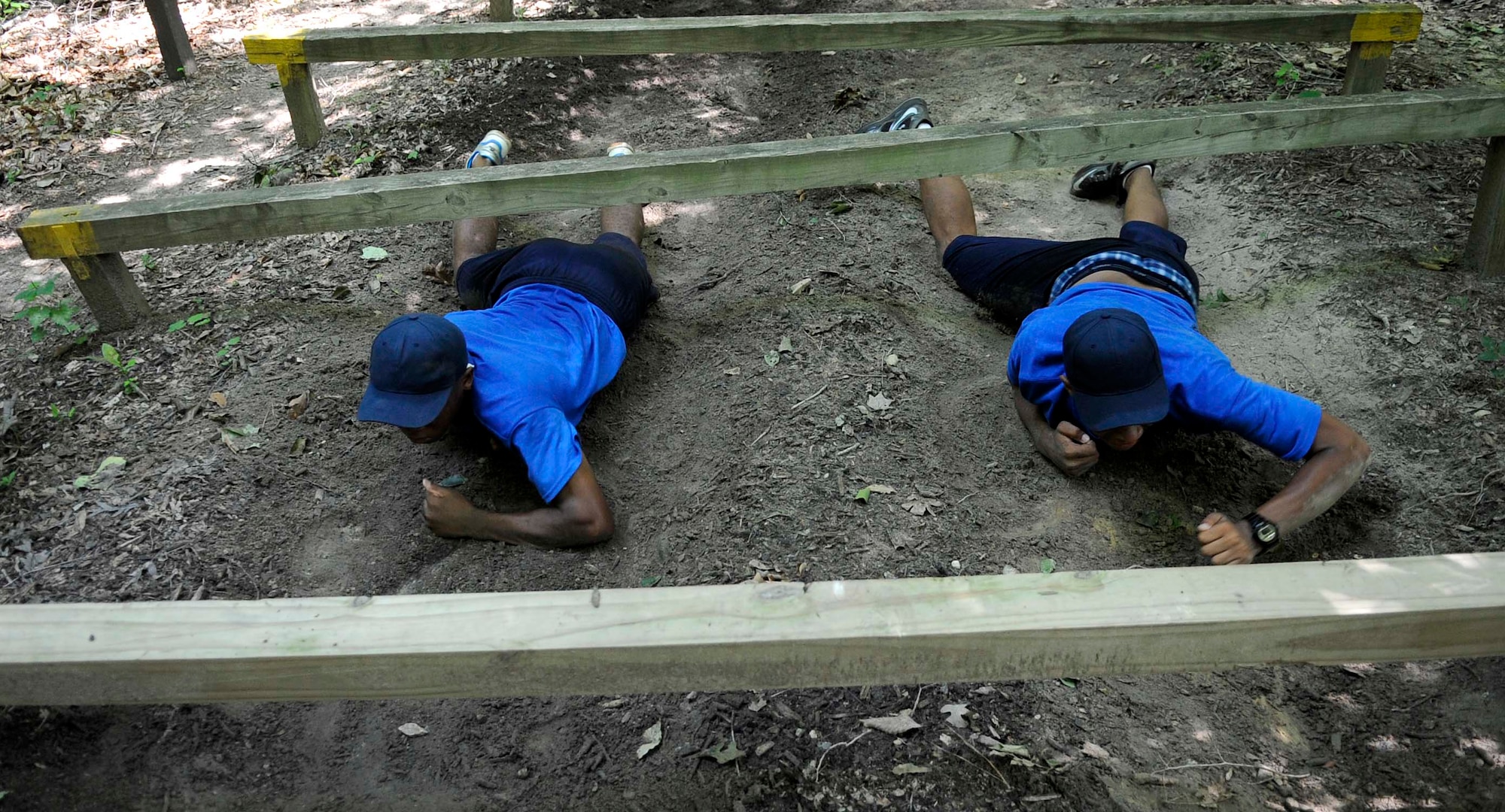 U.S. Air Force Junior Reserve Officers' Training Corps cadets low-crawl through a portion of the obstacle course at Fort Eustis, Va., June 26, 2013. Four different high schools in the local area brought together their AFJROTC cadets to complete the obstacle course as a part of a summer leadership course. (U.S. Air Force photo by Staff Sgt. Dana Hill/Released)