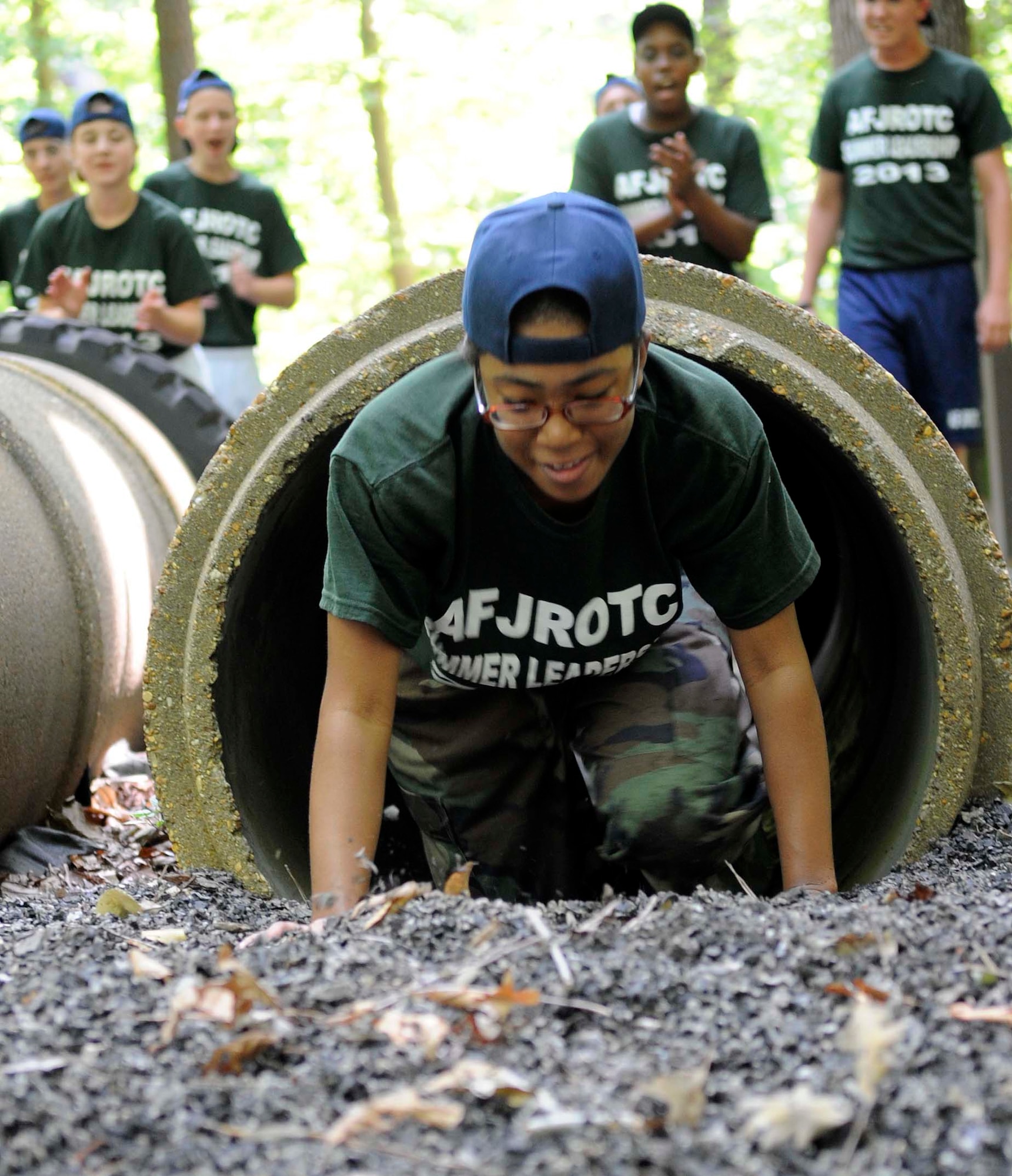 Vera Shinard, a U.S. Air Force Junior Reserve Officers' Training Corps cadet, crawls through a tunnel on the obstacle course at Fort Eustis, Va., June 26, 2013. More than 40 local AFJROTC cadets completed the obstacle course as a part of a summer leadership course. (U.S. Air Force photo by Staff Sgt. Dana Hill/Released)