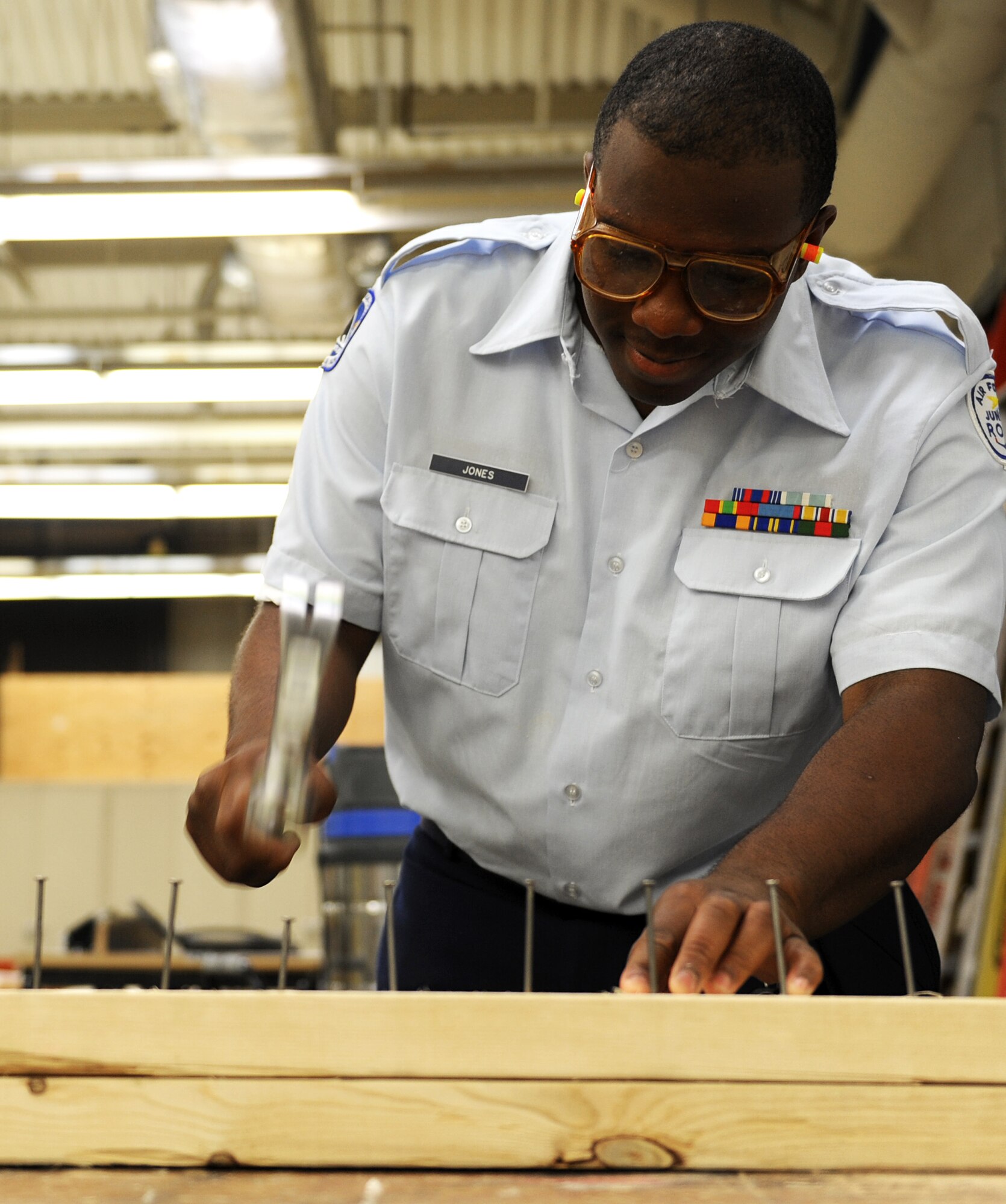 Travis Jones, a U.S. Air Force Junior Reserve Officers' Training Corps cadet, hammers a nail during the AFJROTC shadow day at Langley Air Force Base, Va., June 25, 2013. Jones shadowed Service members from the 633rd Civil Engineer Squadron, learning the importance of their mission. (U.S. Air Force photo by Airman 1st Class Kimberly Nagle/Released)