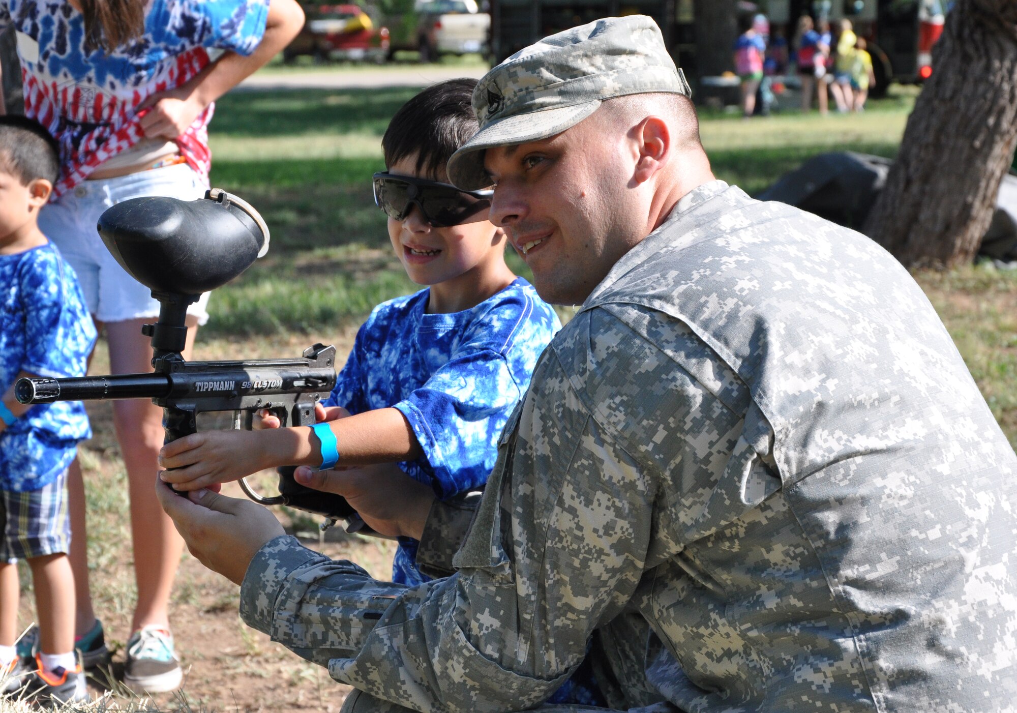 SAN ANGELO, Texas – Army Staff Sgt. Noe Depriest, 344the Military Intelligence Batallion Senior Ops NCO, assists a camp participant with shooting a paintball gun at the 35th annual West Texas Rehabilitation Center Summer Camp, June 18. Goodfellow volunteers helped support the camp by putting on a paintball demonstration and bringing out one of the Goodfellow fire trucks for the children to see. (U.S. Air Force photo/ Airman 1st Class Erica Rodriguez)