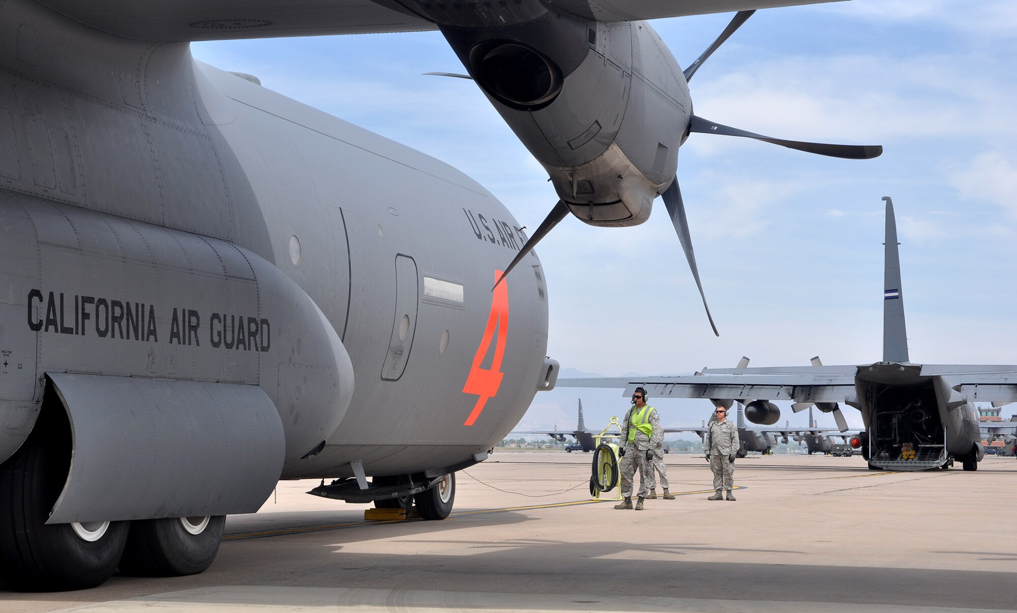 A C-130J crew chief with the California Air National Guard coordinates with aircrew prior to the aircraft's launch June 24, 2013, from Peterson Air Force Base, Colo., to support the West Fork Complex fires. Aircraft and Airmen from the California ANG's 146th Airlift Wing, together with Air Force Reservists with the 302nd AW, have joined together to provide aerial firefighting support to Rocky Mountain wildfires. The aircraft make use of the Modular Airborne Fire Fighting System, or "MAFFS," to drop fire retardant in support ground forces. Since July 25, MAFFS aircraft and aircrews have dropped 169,000 gallons of retardant in 2013. (U.S. Air Force photo/Tech. Sgt. Stephen J. Collier)