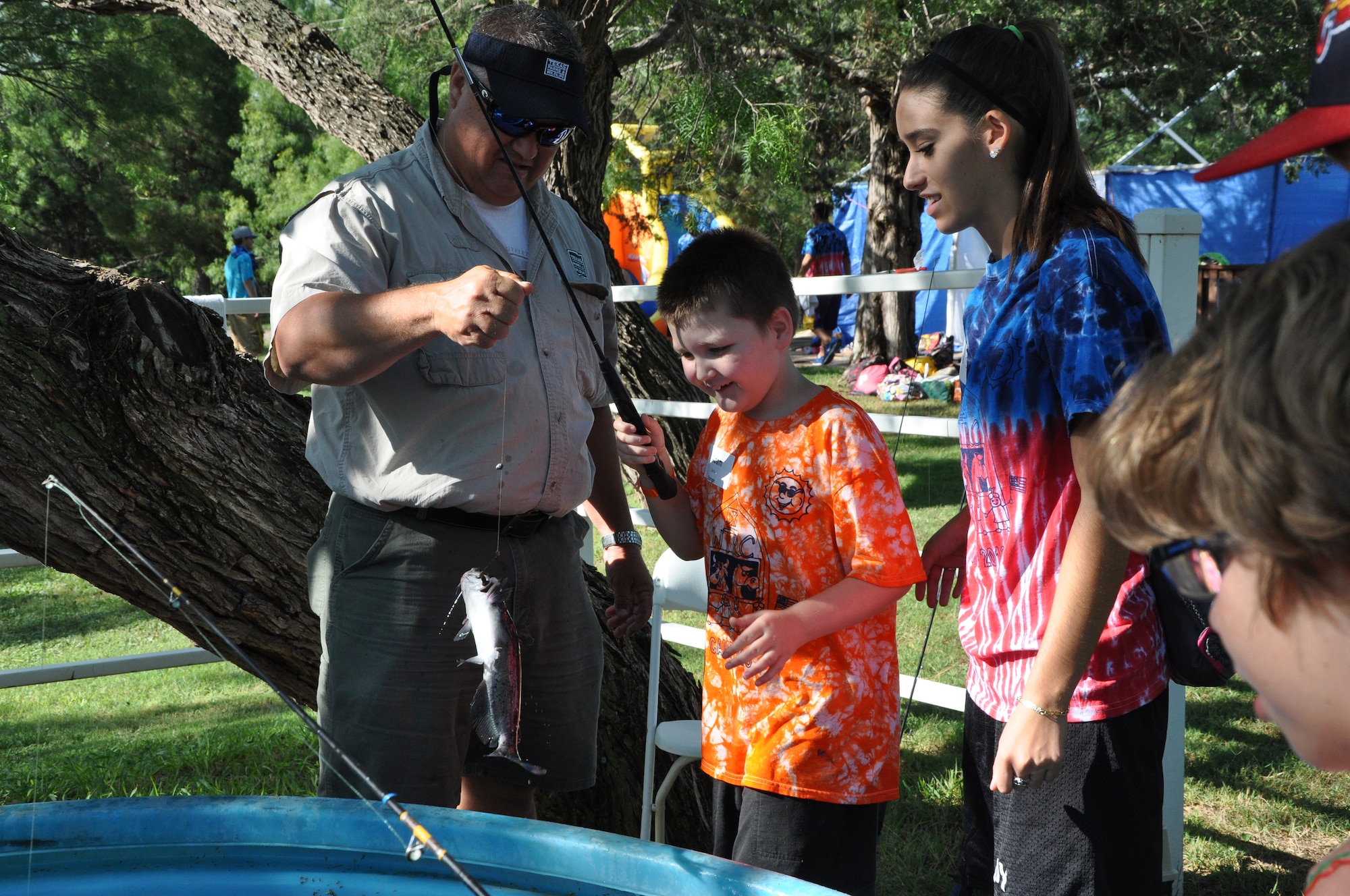 SAN ANGELO, Texas - Adam, a camper, reels in a catfish at the 35th annual West Texas Rehabilitation Center Summer Camp, June 18. Fishing was one of the activities available for the children with special needs at the camp, which gives them a chance to try new experiences. (U.S. Air Force photo/ Airman 1st Class Erica Rodriguez)