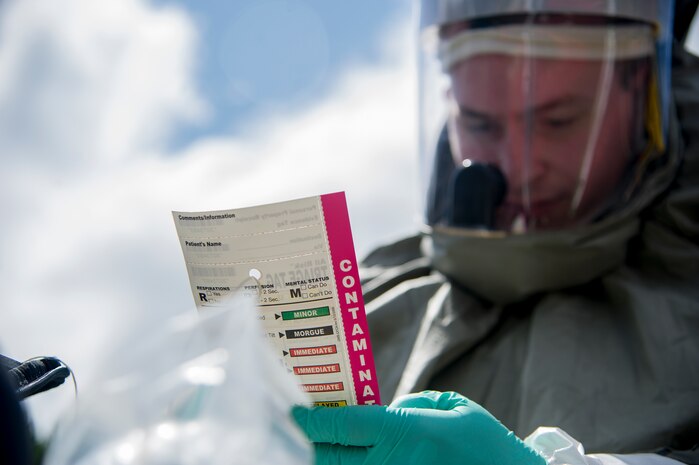 A Sailor from the Navy Health Clinic Charleston marks symptoms during the final "timed" exercise on the second day of the First Receivers Operation Training course June 21, 2013, at Joint Base Charleston - Weapons Station, S.C.  The 16-hour course consisted of one, eight-hour day of class lecture and a second eight-hour day of "hands-on" teamwork training to include a final "timed" exercise. NHCC team’s mission capable time was three minutes and forty-six seconds. Their set up completion time was seven minutes and fifteen seconds. They exceeded U.S. Navy standard times despite being their first time training with the equipment. (U.S. Air Force photo/Staff Sgt. Rasheen Douglas)