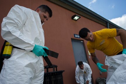 Sailors from the Navy Health Clinic Charleston don their personal protective equipment to begin their final "timed" exercise during their second day of the First Receivers Operation Training course June 21, 2013, at Joint Base Charleston - Weapons Station, S.C.  The 16-hour course consisted of one, eight-hour day of class lecture and a second eight-hour day of "hands-on" teamwork training to include a final "timed" exercise. NHCC team’s mission capable time was three minutes and forty-six seconds. Their set-up completion time was seven minutes and fifteen seconds. They exceeded U.S. Navy standard times despite being their first time training with the equipment. (U.S. Air Force photo/Staff Sgt. Rasheen Douglas)