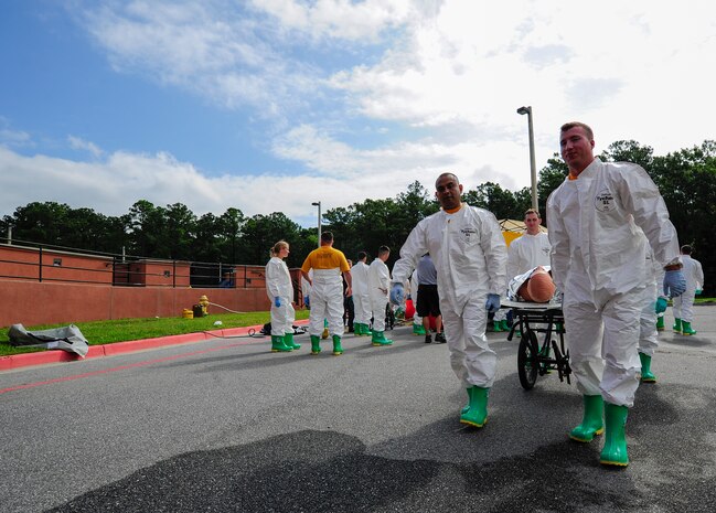 Sailors from the Navy Health Clinic Charleston simulate carrying a patient to be examined after going through the decontamination tent during the First Receivers Operation Training course June 21, 2013, at Joint Base Charleston - Weapons Station, S.C. The NHCC team participated in the FROT course to educate their Sailors on life-saving skills consisting of triage, initiate field treatment, decontaminate and save victims from Chemical, Biological, Radiological/Nuclear, or Hazardous Material. The 16-hour course consisted of one, eight-hour day of class lecture and a second eight-hour day of "hands-on" teamwork training to include a final "timed" exercise. (U.S. Air Force photo/Staff Sgt. Rasheen Douglas)