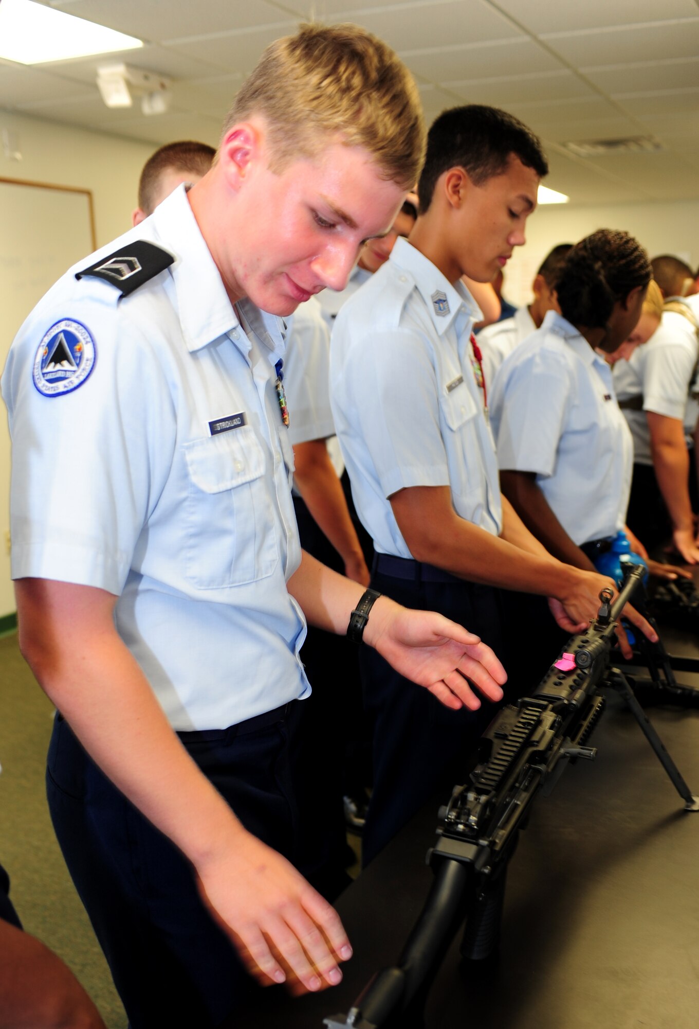 Kenyon Strickland, U.S. Air Force Junior Reserve Officers’ Training Corps cadet, looks at a rifle during the AFJROTC shadow day at Langley Air Force Base, Va., June 25, 2013. AFJROTC cadets were taken to Combat Arms Training and Maintenance to learn about one aspect of the 633rd Security Forces Squadron’s mission. (U.S. Air Force photo by Airman Areca T. Wilson/Released)