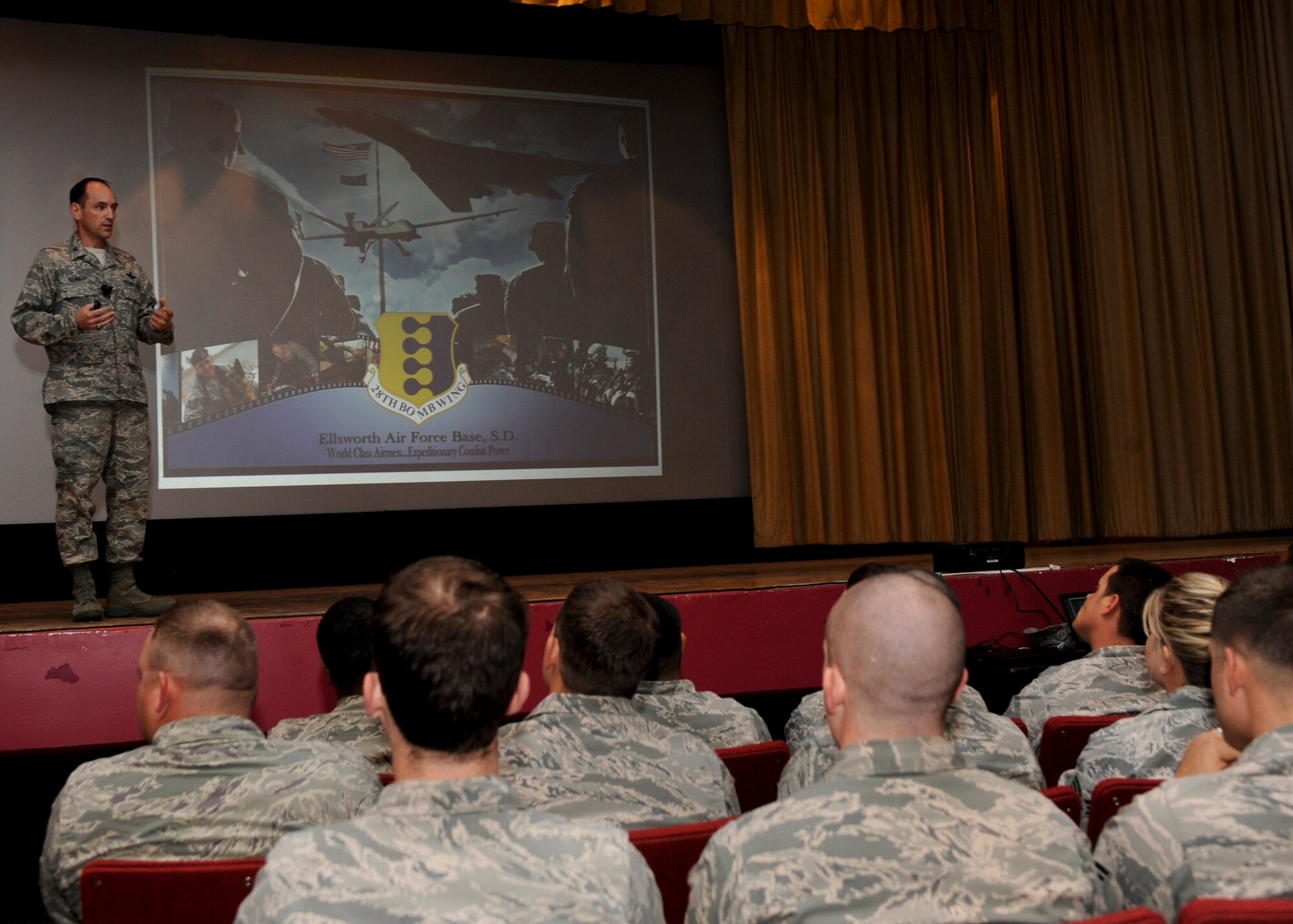 Col. Kevin Kennedy, 28th Bomb Wing commander, addresses Airmen during one of the four briefings he delivered at the base theater as part of the Sexual Assault Prevention Stand-Down Day at Ellsworth Air Force Base, S.D., June 21, 2013. Kennedy discussed the current climate in the Air Force regarding sexual assault and how it is imperative that every individual takes responsibility to create an atmosphere of respect and safety for every Airman. (U.S. Air Force photo by Airman 1st Class Anania Tekurio/Released)
