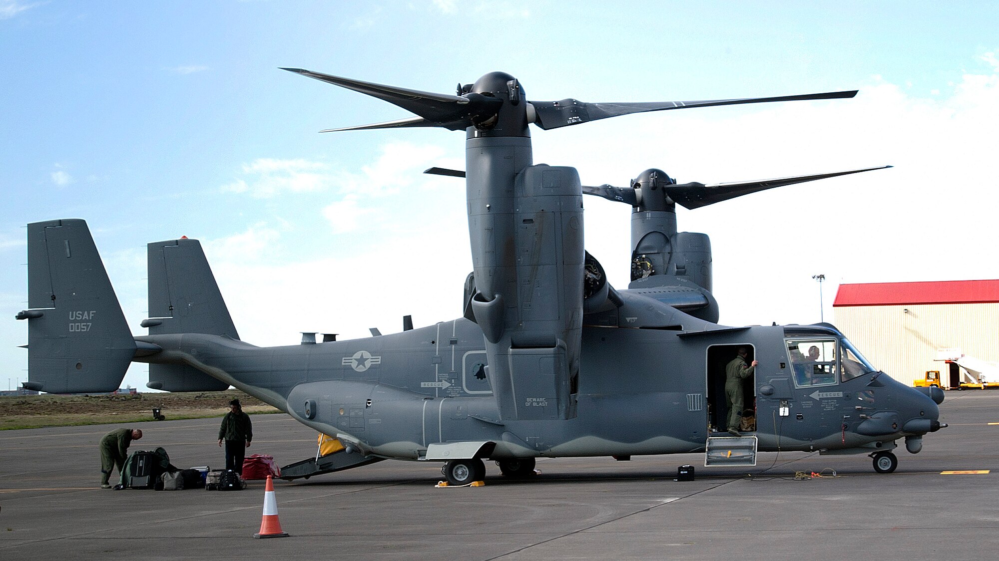 Airmen unload a CV-22B Osprey June 21, 2013, in Keflavik, Iceland.  The aircraft landed in Iceland to allow for crew rest and refueling during its journey to RAF Mildenhall, England. The CV-22s fill the role previously accomplished by the MH-53 Pave Low helicopter for the 352nd Special Operations Group. However, the CV-22 combines the vertical takeoff, hover and vertical-landing qualities of a helicopter with the long-range, fuel-efficiency and speed of a turboprop aircraft. (U.S. Air Force photo by Senior Airman Laura Yahemiak/Released)