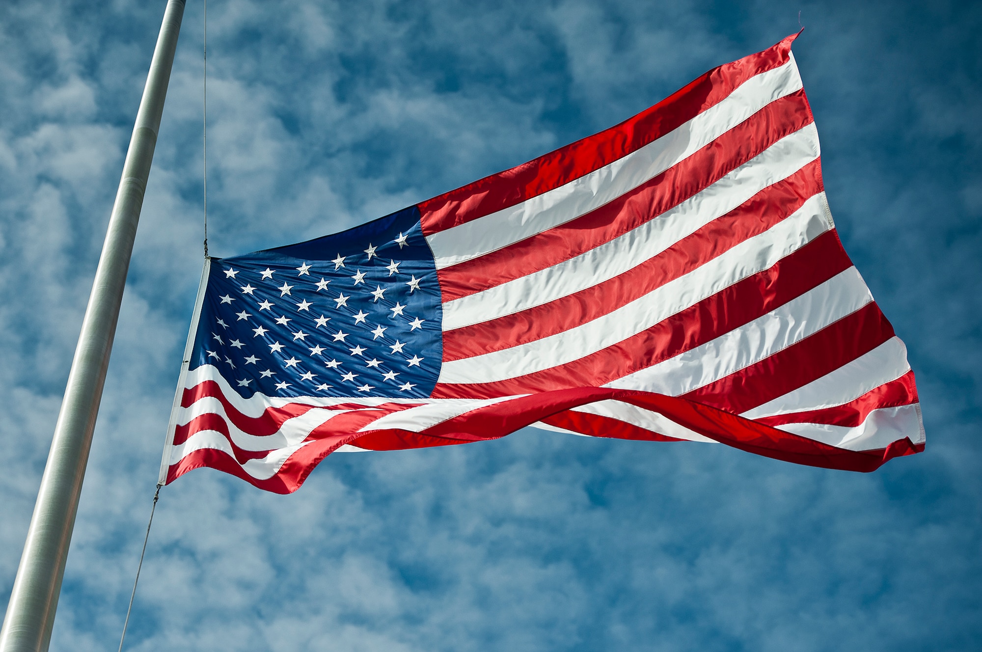 The Eglin Air Force Base flag flaps in the wind below a blue Florida sky.  Happy Independence Day from Team Eglin.  (U.S. Air Force photo/Samuel King Jr.)