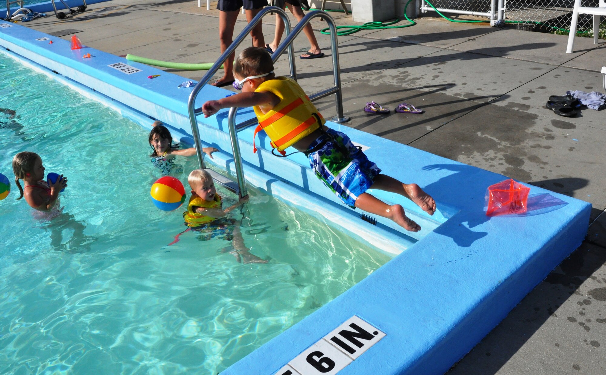 Rylan Head, son of deployed 325th Force Support Squadron Commander Lt. Col. Brad Head, jumps into the pool while others watch. Tyndall's Airmen and Family Readiness center hosted a "Hearts Apart" pool party June 25 for families of deployed servicemembers. (U.S. Air Force photo by 2nd Lt. Andrea Valencia)