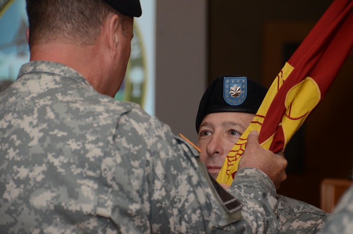 JOINT BASE CHARLESTON - WEAPONS STATION, S.C. — Army Col. Charles Brown 597th Transportation Brigade commander, transfers the guidon to the new 841st Transportation Battalion commander, Lt. Col. Brian Memoli, during a change of command ceremony June 20, 2013, at Joint Base Charleston-Weapons Station. (U.S. Navy photo/ Petty Officer 1st Class Chad Hallford)