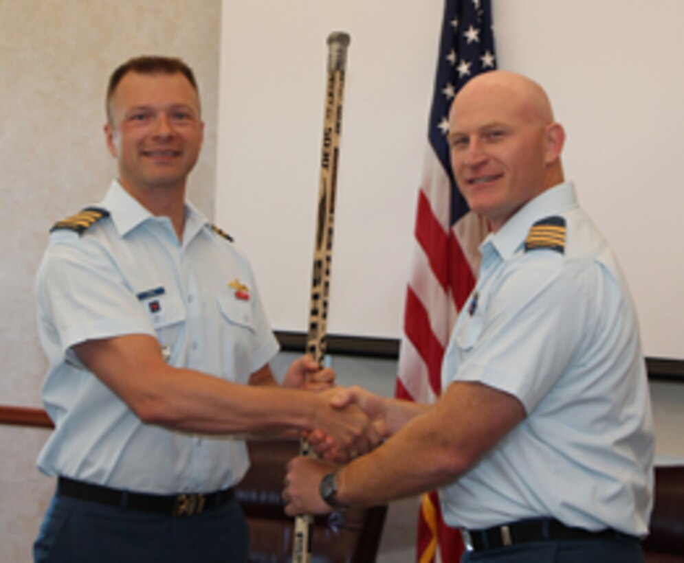 LCol Kyle Paul, right, receives the "ceremonial" change-of-command hockey stick from outgoing Canadian Detachment Commanding Officer LCol Dave Pletz. The Canadian Detachment change of command ceremony was held on June 20 and was presided over LGen J..A.J. Parent, the Deputy Command, NORAD.