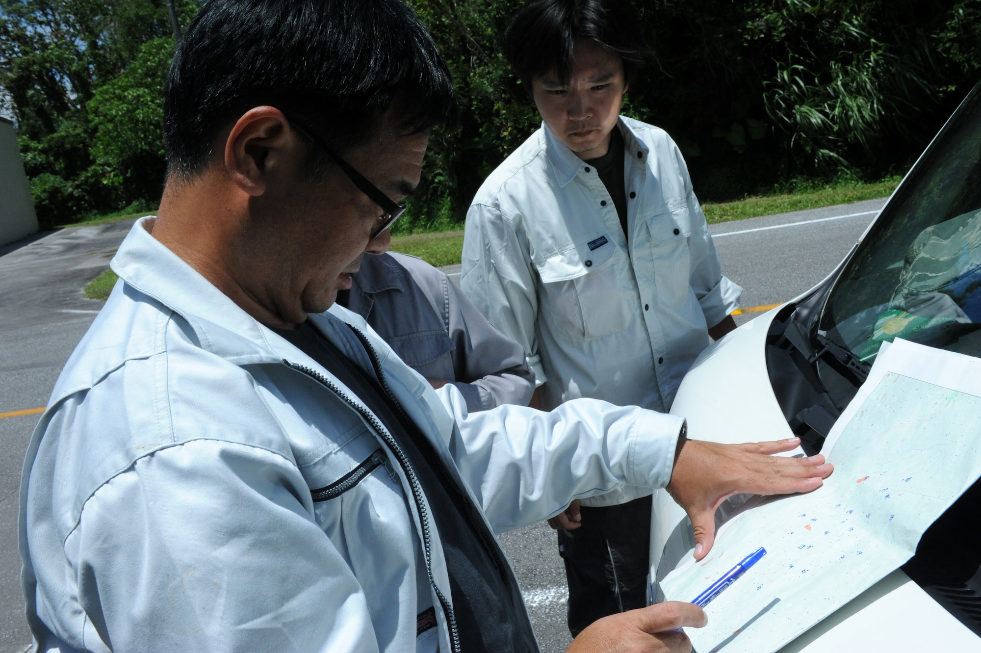 Koki Terada, Okinawa Prefectural Government Institute of Health and Environment lab researcher, views a map on Kadena Air Base, Japan, June 25, 2013. Terada has been a snake handler and researcher for more than 20 years, and teamed up with 18th Civil Engineering Squadron pest management personnel to place snake traps in order to capture and remove specific snake species from the base. (U.S. Air Force photo by Airman 1st Class Hailey R. Davis/Released)