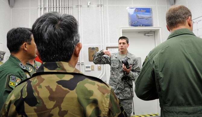 U.S. Air Force Senior Airman Richard Gilliland, 35th Maintenance Squadron aerospace propulsion maintainer, informs 3rd Air Wing leadership the rules and working procedures for working in close proximity of an actively testing jet engine during a tour of a Hush House at Misawa Air Base, Japan, June 25, 2013. Each procedure was created to guarantee the safety of those inside the facility and ear protectors was handed out to protect against loud noise produced by the engine. (U.S. Air Force photo by Airman 1st Class Kenna Jackson)
