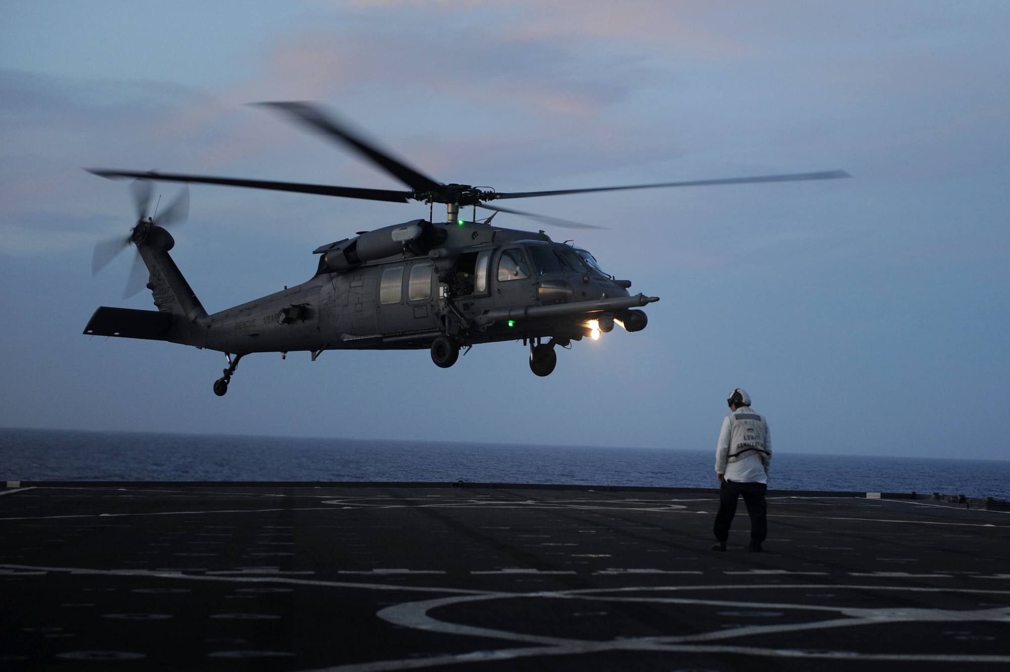 An HH-60G Pave Hawk helicopter prepares to land on the deck of a naval ship off the coast of Okinawa, Japan, June 22, 2013. Pilots with the 33rd Rescue Squadron landed the helicopter approximately 30 times during the day and 30 times during the night in order to fulfill a training requirement of landing on naval ships in order to remain mission ready at all times. (U.S. Air Force photo by Airman 1st Class Hailey R. Davis/Released)