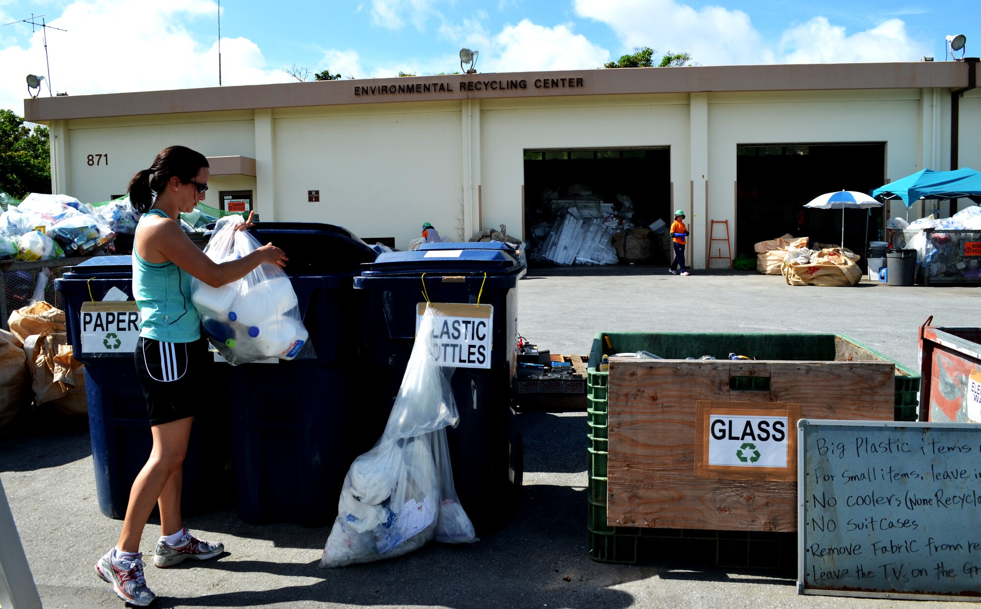 U.S. Air Force Capt. Mayara Coulter, from the 18th Medical Operations Squadron Mental Health flight, separates recyclable items at the recycle center on Kadena Air Base, Japan, June 21, 2013. The recycle center is located at building 871, behind Karing Kennels, near gate 4. (U.S. Air Force photo by Capt. Heather Boytim/Released)