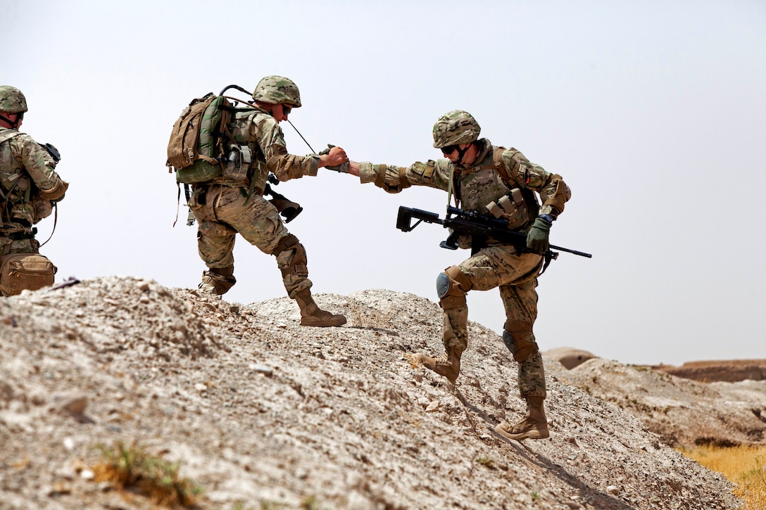 A Georgian soldier helps another soldier while conducting a dismounted ...