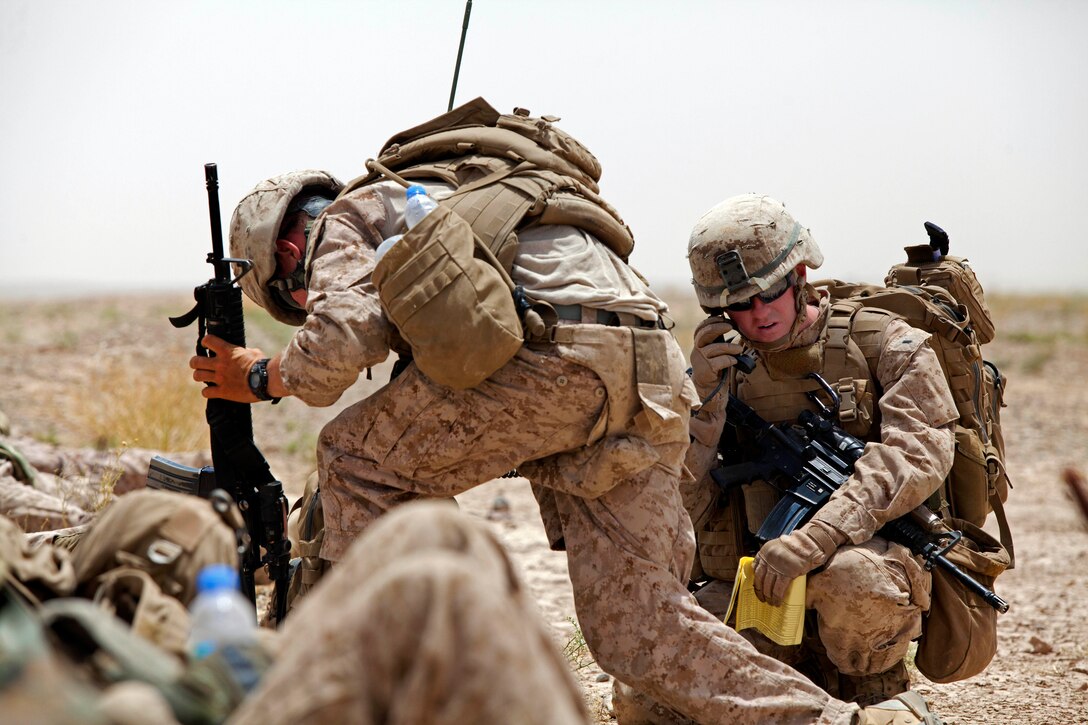 U.S. Marine Corps 1st Lt. Stephen Desmond, right, relays his positions to his leadership team by radio while conducting Operation Northern Lion in Mohammad Abad village in Helmand province, Afghanistan, June 24, 2013. Desmond is assigned to Georgian Liaison Team-9.