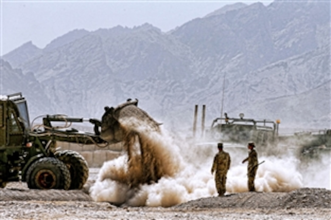 A U.S. soldier operates a bulldozer to fill a hole before closing down Forward Operating Base Hadrian near Deh Rawud village in Uruzgan province, Afghanistan, June 22, 2013. The soldiers are assigned to the 3rd Infantry Division's 2nd Brigade Combat Team.