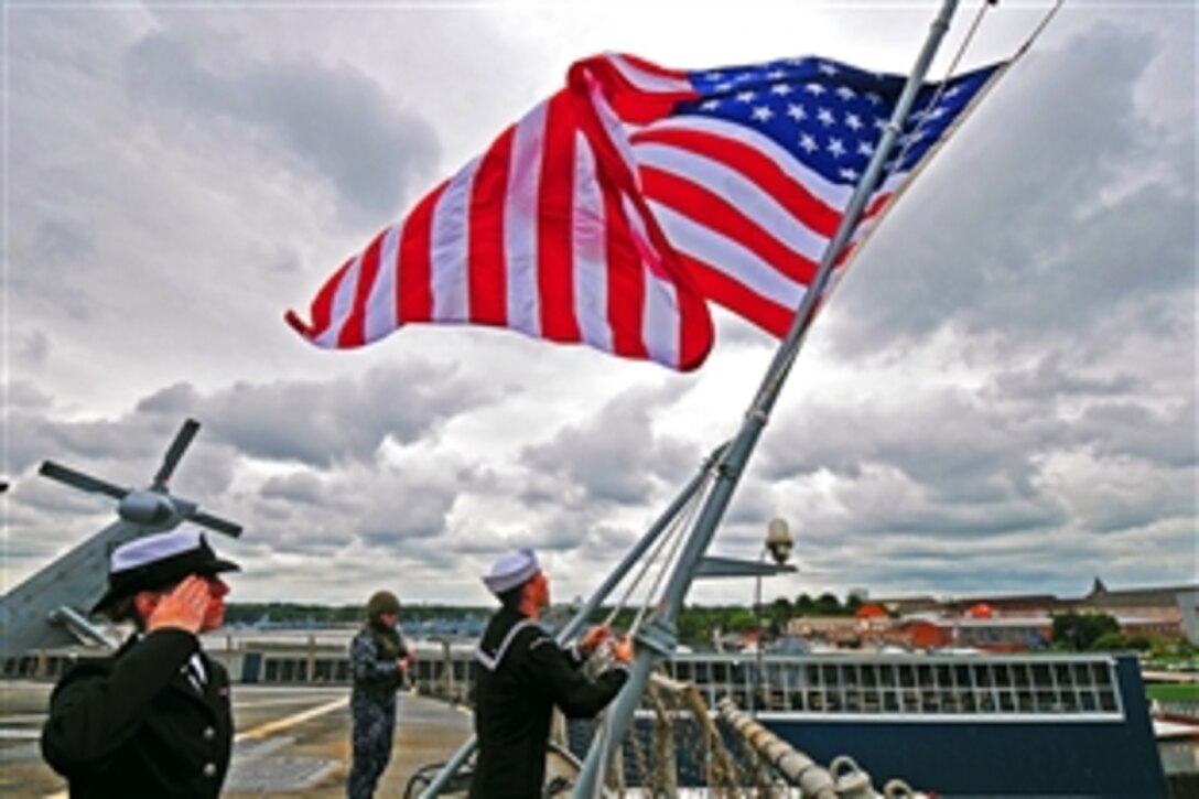 U.S. Navy sailors lower the American flag as they get underway after concluding exercise Baltic Operations 2013 in Kiel, Germany, June 25, 2013. The sailors are assigned to the amphibious command ship USS Mount Whitney. BALTOPS is an annual multinational exercise to enhance maritime capabilities and interoperability with partner nations, and promote maritime safety and security in the Baltic Sea.