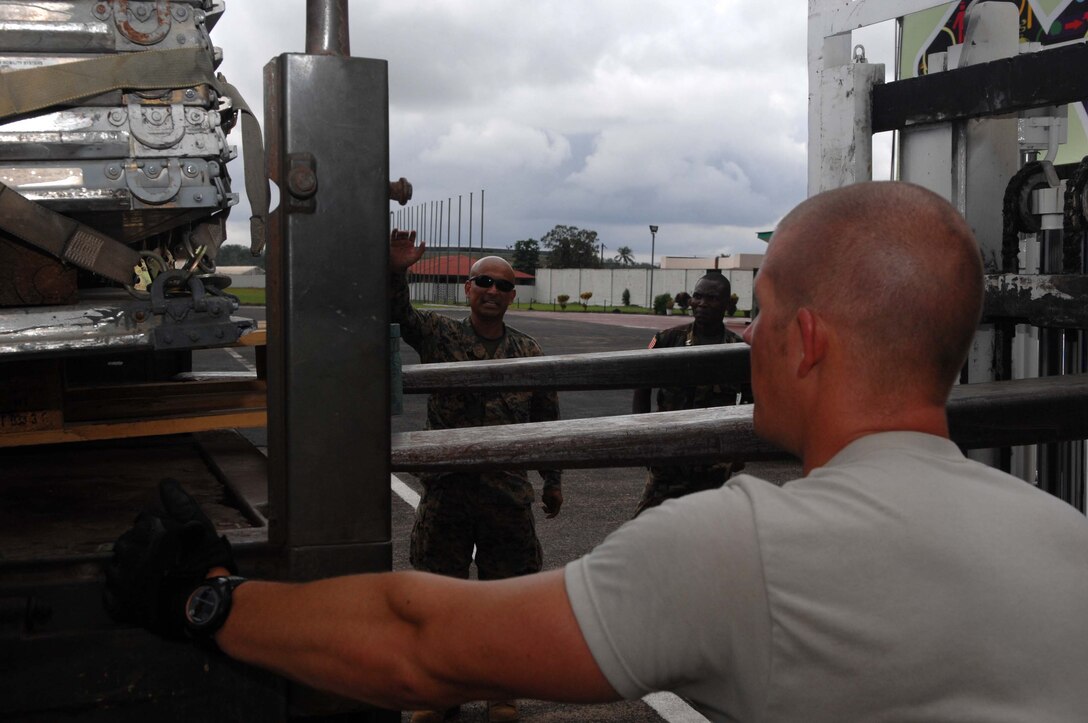 U.S. Air Force Staff Sgt. Merrill Slepica, 570th Global Mobility Squadron aerial porter from Travis Air Force Base, Calif., and U.S. Marine Corps Gunnery Sgt. Marvin Hernandez-Garcia, Armed Forces of Liberia logistics mentor deployed with Operation ONWARD LIBERTY from Camp Courtney, Okinawa, safely guide a forklift operator who loads cargo onto an AFL truck at Roberts International Airport June 17, 2013.  Three Airmen from Travis AFB flew to Monrovia to support U.S. servicemembers deployed with OOL in preparation for the AFL’s deployment to the African-led International Support Mission in Mali.  The mission is the AFL’s first international peacekeeping operation as a restructured force.  ONWARD LIBERTY is a U.S. Marine Corps Forces Africa-led operation comprised of joint U.S. servicemembers who mentor and advise the AFL in order to develop a national military that is responsible, operationally capable and respectful of civilian authority and the rule of law.  OOL’s goal is to assist the AFL in building a professional and capable military force that can effectively contribute to the overall security environment in Liberia.
