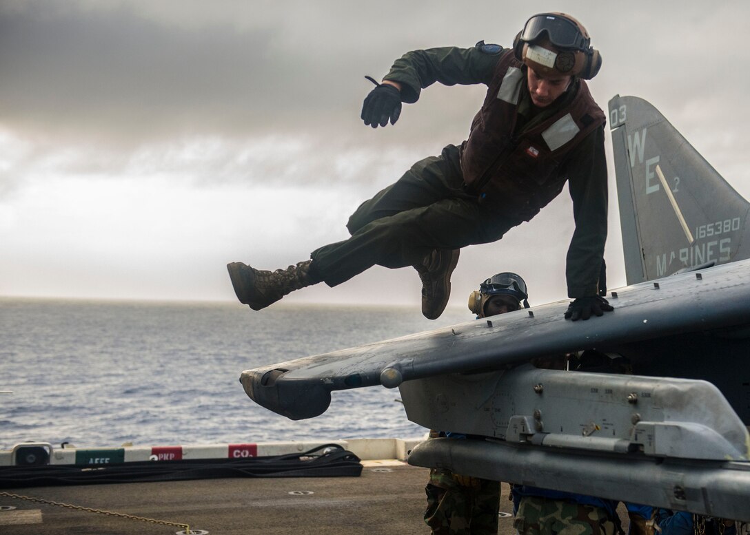 Corporal Ben Hudson, a fixed-wing aircraft mechanic with Marine Medium Tiltrotor Squadron 265 (Reinforced), 31st Marine Expeditionary Unit, leaps off the wing of an AV-8B Harrier aircraft after helping to move the aircraft to a different area of the flight deck, June 26. The Marines and Sailors of the 31st MEU recently embarked the ships of Amphibious Squadron 11 to begin their summer patrol of the Asia Pacific region. 