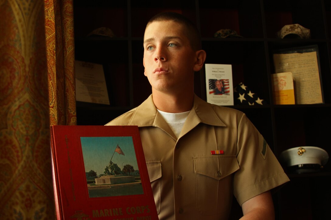 Private First Class Scott A. Blake, Jr. is photographed in his home on June 19, 2013, among Marine Corps mementos collected by his family throughout the past 78 years. Blake joined the Marine Corps to continue his family’s tradition of service and sacrifice. (Marine Corps Photo by Sgt. Aaron Rooks)