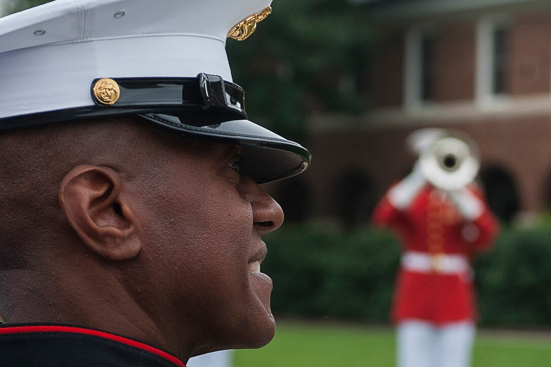 Sgt. Maj. Eric J. Stockton, former Marine Barracks Washington, D.C. sergeant major, smiles as he watches the U.S. Marine Drum & Bugle Corps perform during a relief and appointment ceremony at the Barracks June 27. During the ceremony, Stockton relinquished his post to Sgt. Maj. Angela M. Maness and retired after more than 30 years of service.