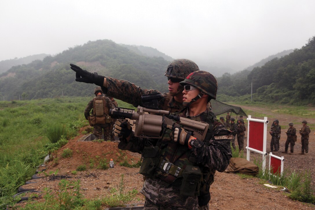Republic of Korea Marine Cpl. Kyung Hoo Park prepares to fire the M32 40 mm automatic grenade launcher as U.S. Marine Cpl. Troy A. Biggs identifies the target June 18 at Su Seong Re Range, Pohang, Republic of Korea, during a live-fire exercise. Biggs is a military policeman with 3rd Law Enforcement Battalion, III Marine Expeditionary Force Headquarters Group, III MEF, and Park is a military policeman with 1st Division, Military Police Company, 1st Republic of Korea Marine Corps Division. Photo by Lance Cpl. David N. Hersey