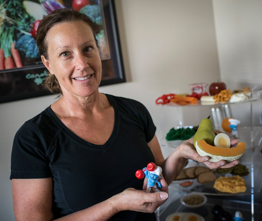 Trish Stephens, 366th Aerospace Medicine Squadron Heath and Wellness Center nutritionist, holds up some of her dietary visual aids in the Fitness Center at Mountain Home Air Force Base, Idaho, June 26, 2013. Stephens provides one-on-one and group nutrition counseling for free to military members and their dependents. (U.S. Air Force photo/Tech. Sgt. Samuel Morse)
