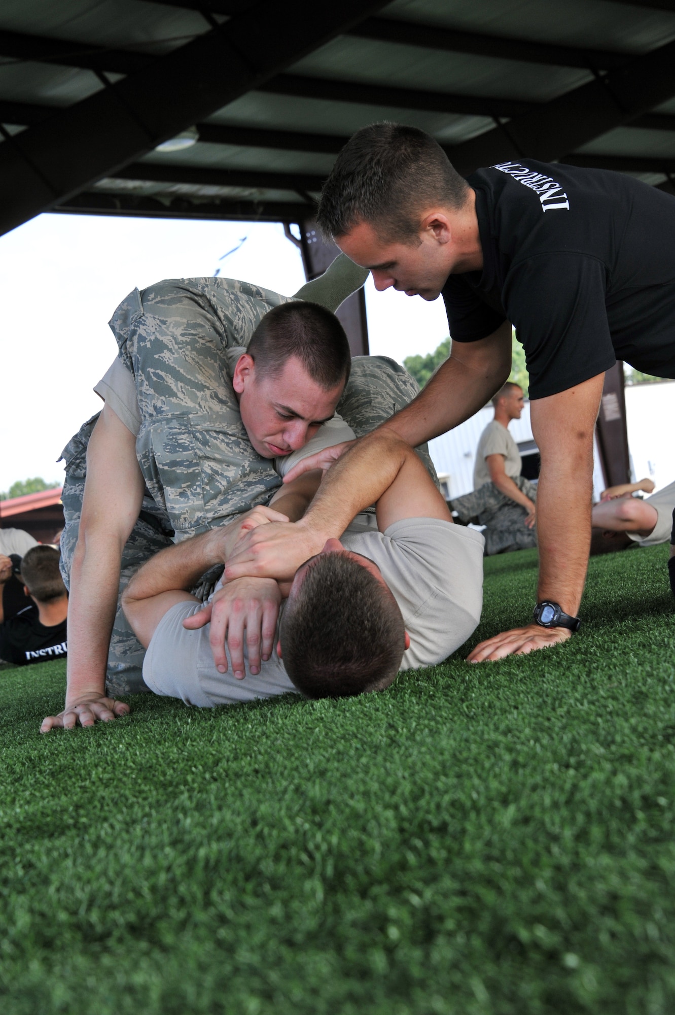 A combatives instructor helps show proper technique to cadets during a combatives portion of AFROTC summer field training at Maxwell Air Force Base, June 13. The cadets are split into flights where they will attack the training program teamed up with others from all over the U.S. (U.S. Air Force photo by Airman 1st Class William Blankenship) 
